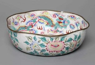 A CANTON ENAMEL BOWL of lobed circular form, painted in bright colours with dragons on a white