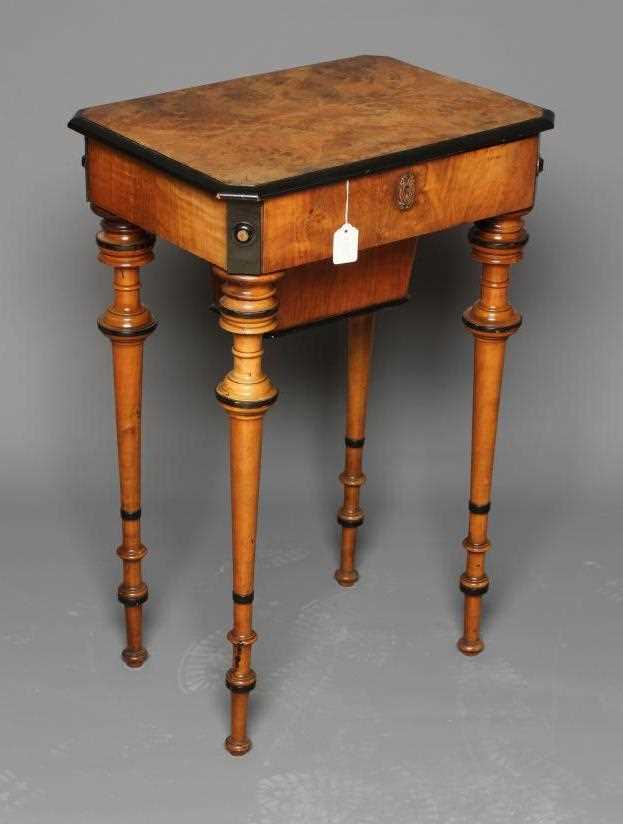 A VICTORIAN WALNUT AND MAPLE SEWING TABLE of canted oblong form with ebony trim, the hinged lid