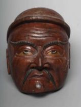 A JAPANESE CARVED WOOD NOH MASK painted in red, black and white, with holes for the eyes and