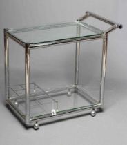 AN ART DECO CHROME TROLLEY of oblong two tier form with glass shelves, chrome bottle housing and