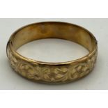 A 9 carat yellow gold bangle, engraved to one side. Weight 18gm.