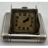 An Art Deco Dunhill silver miniature travel clock, engine turned case with hinged divided doors