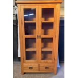 An oak glazed display cabinet/ bookcase with 3 shelves over 2 drawers. 181 h x 100 w x 40cm d.