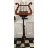 An Edwardian mahogany adjustable music stand. The lyre shaped music support on an extending