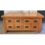 An oak coffee table with four double ended drawers. 51 h x 110 w x 60cm d.