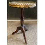 A mahogany continental style tripod occasional table with round marble and gilt metal galleried top.