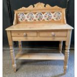A pine washstand with tiled back and two drawers and shelf below. 108 h x 90 w x 44cm d.