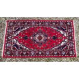 A Persian rug measuring 165cm x 92cm.