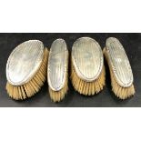 Two pairs of identical men's grooming brushes with silver tops, Birmingham 1924 Williams Adams,