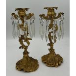 A pair of ormolu candlesticks with crystal drops. 26cm h.