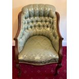 A mahogany framed deep button back upholstered armchair on front cabriole legs and porcelain
