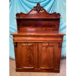 A mahogany chiffonier, carved shaped back with a single shelf raised on scroll supports, above one