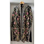 An Indian embroidered long length silk jacket on black background with split sides richly hand