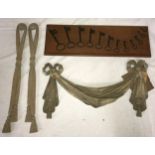 A pair of tasselled wooden carved wall hangings in a ribbon design 53.5cm h x 5.5cm w along with a