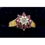 An 18 carat gold cluster ring set with rubies and diamond with bark style decoration to the shank.