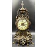 A large ornate brass mantle clock with white enamel face. 49cm h.