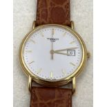 An 18ct gold cased boxed Tissot wristwatch with brown leaf strap. Winds and goes, very good