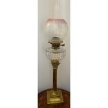 A 19thC oil lamp with brass Corinthian column, clear glass reservoir and etched pink and clear glass