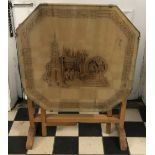 An octagonal wooden carved oriental tip top table depicting men with removable glass top 53cm h x