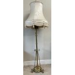 A decorative scrolled brass standard lamp with shade converted from an oil lamp. 151cm h without