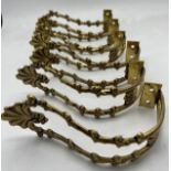A set of six decorative brass curtain tie backs.