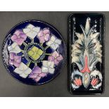 Two Moorcroft pin trays one circular with blue, purple and green flower design 16cm d the other