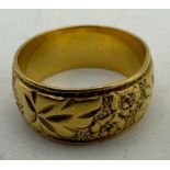 A 22ct gold wide band wedding ring with engraved decoration. Maker Charles Green & Son,