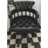 A leather deep button back mahogany framed swivel office chair.