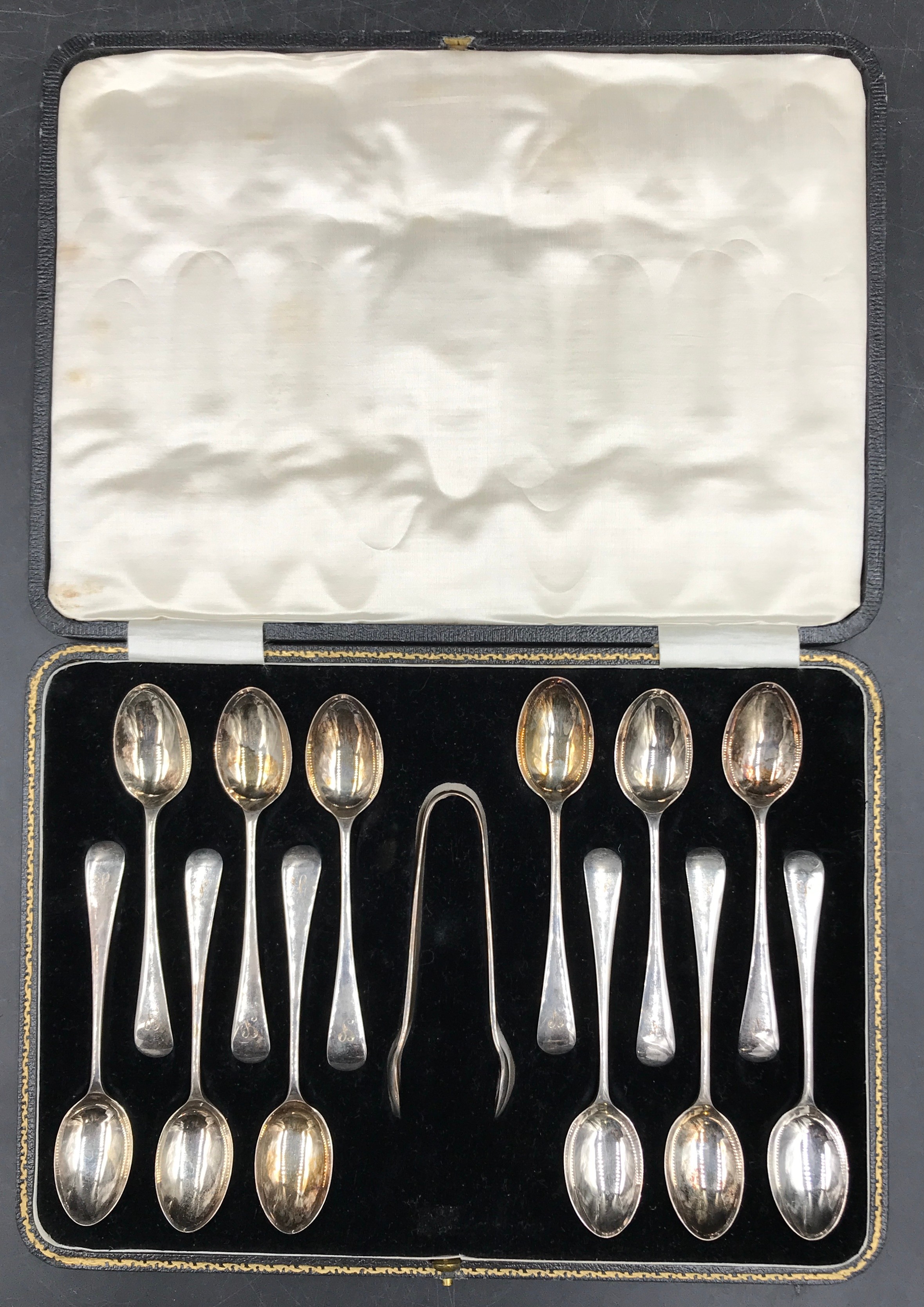 A boxed set of 12 initialled silver teaspoons and sugar tongs Sheffield 1930 by Francis Howard Ltd