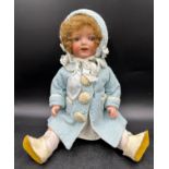 An Armand Marseille 1330 bisque headed doll in vintage clothing with blue sleeping lashed eyes and