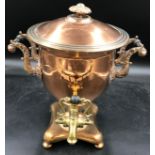 A brass and copper 2 handled samovar, on a shaped quatrefoil base and bun feet 36.5cm h.