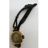 An 18 carat gold cased ladies wristwatch with leather strap. Not in working condition.