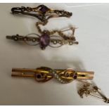 Three Edwardian bar brooches set with seed pearls and purple stones. Two with safety chains. Total