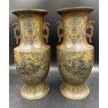 A pair of heavy decretive twin handled bronze vases relief cast in brass and other metals with birds
