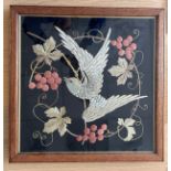 An early 20thC oak framed needlework depicting bird amongst vines 50cm x 50cm.