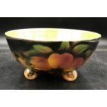 A ceramic fruit lustre bowl decorated in peaches on three scroll feet 23cm d.