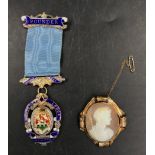 A cameo brooch along with a hallmarked silver masonic founders medal for St. Quentin's lodge.