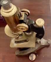 A vintage heavy brass and iron microscope with lenses and slides. 35cm h.