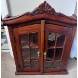 A two door wall mounted display cabinet with brass drop handles and interior shelves. 50 w x 14 d