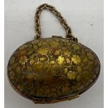 A decorative brass egg shaped thimble case containing a Chester silver thimble 1909, maker Charles