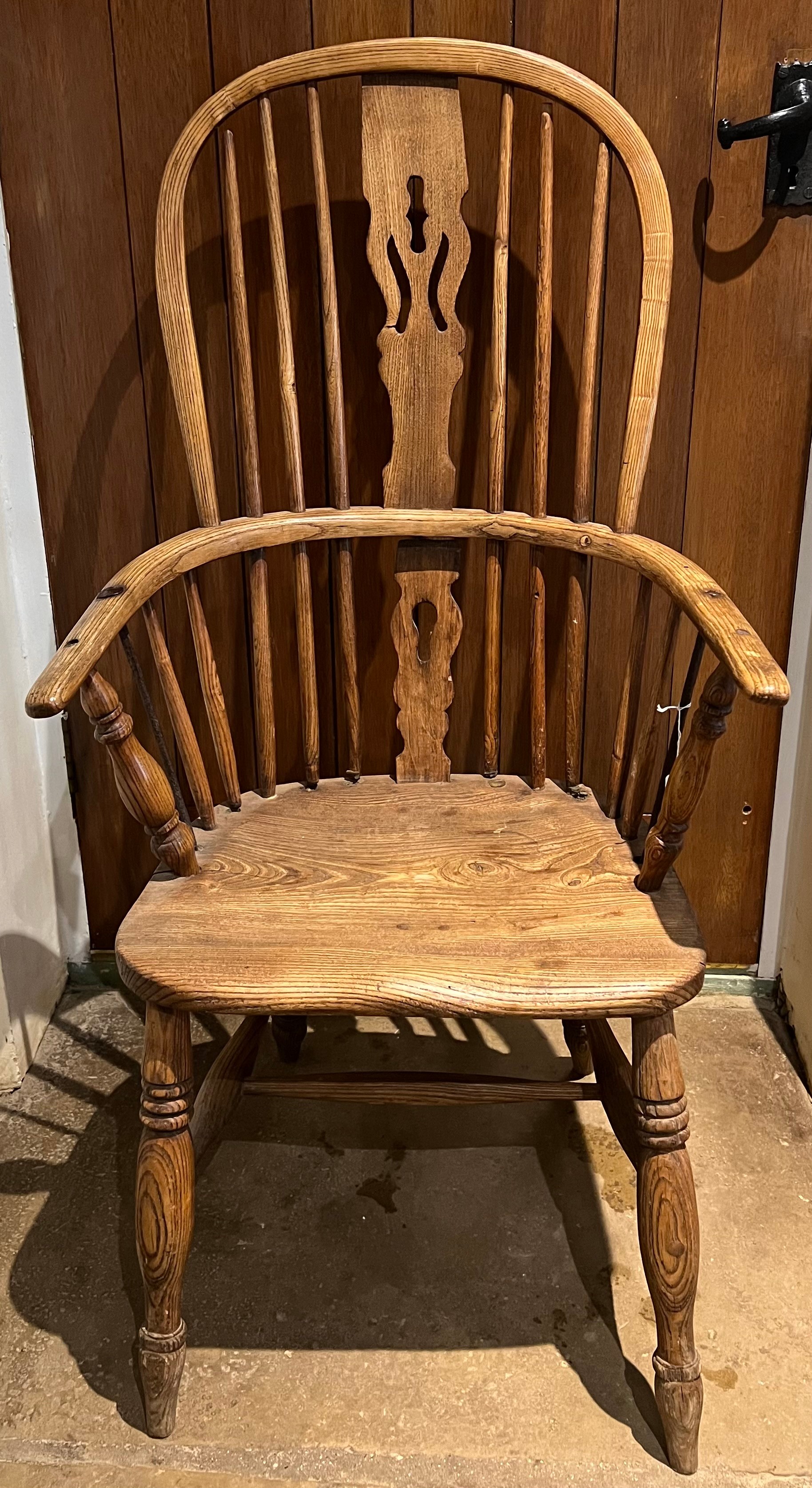 A 19thC high backed Windsor chair in ash and elm.