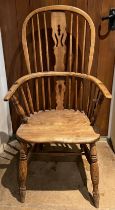 A 19thC high backed Windsor chair in ash and elm.