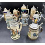 A selection of German beer steins most having zinc lids with embossed hand decorated designs.