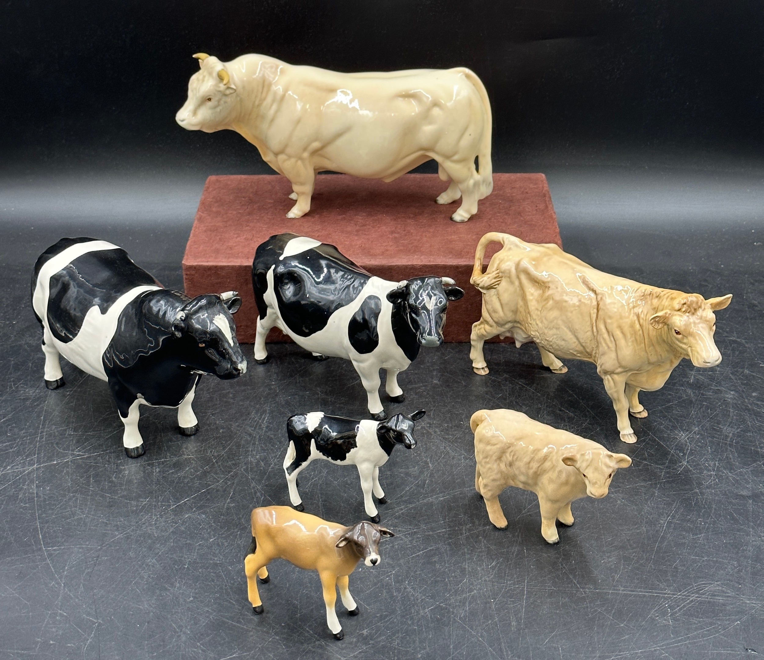 A collection of seven Beswick figures of cattle to include, a Charolais bull, cow and calf, a