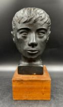 A painted black terracotta bust of male on a wooden stand, bust approx 27cm on stand approx 36cm