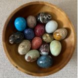 A collection of specimen polished eggs (15) presented in a wooden bowl 30 cm d to include onyx,