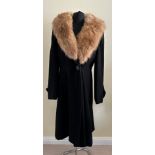 A ladies black coat with a fur collar with 'Marlbeck Model' label and button details to the cuff