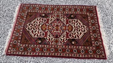 A vintage Persian Ghomshe hand knotted wool rug in autumnal colours. 130 x 198cm.