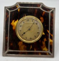 An eight day clock mounted in silver and tortoiseshell frame, London 1906. Approx. 10 x 10cm.