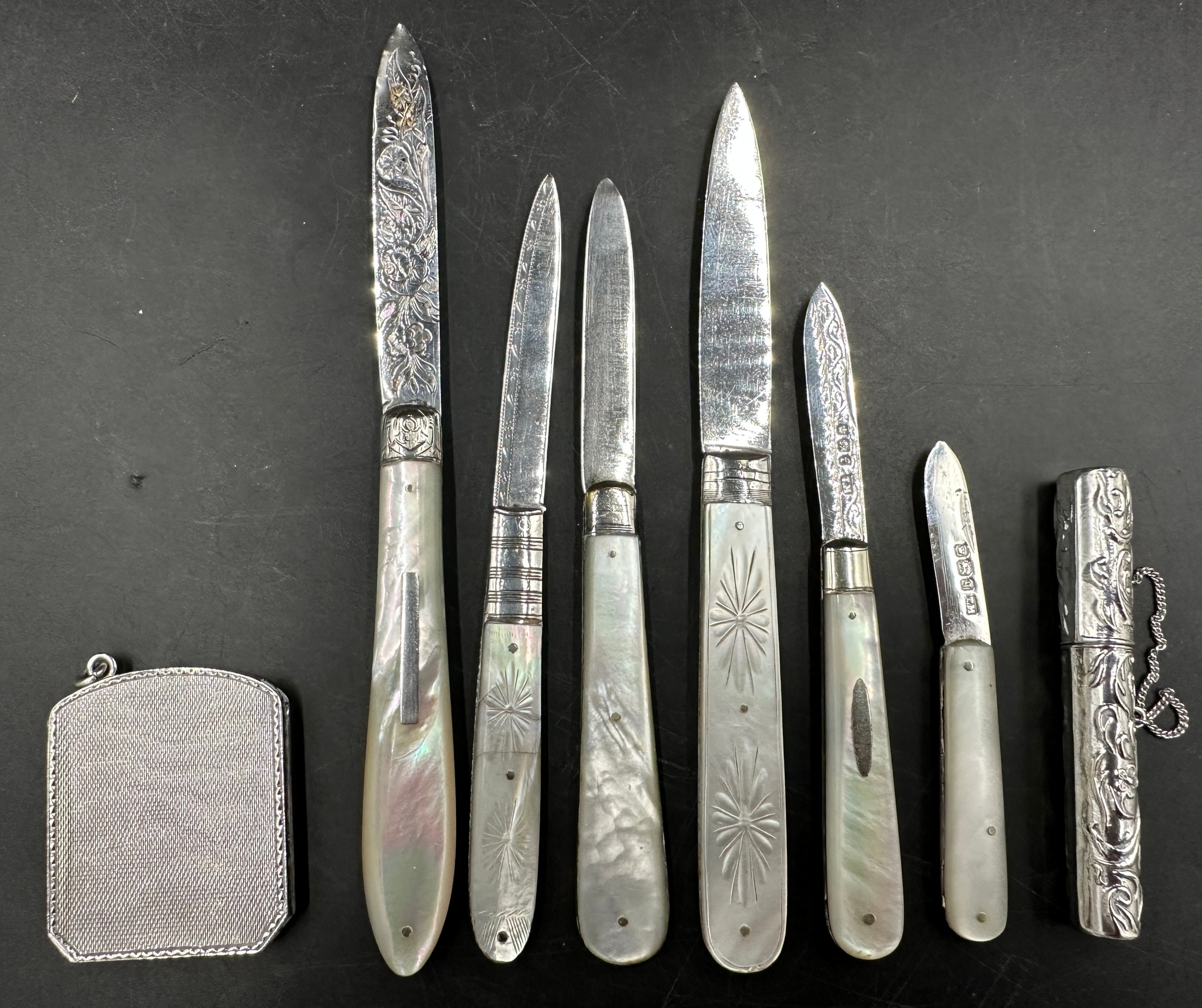 A collection of six hallmarked silver mother of pearl fruit knives and a cylindrical case with